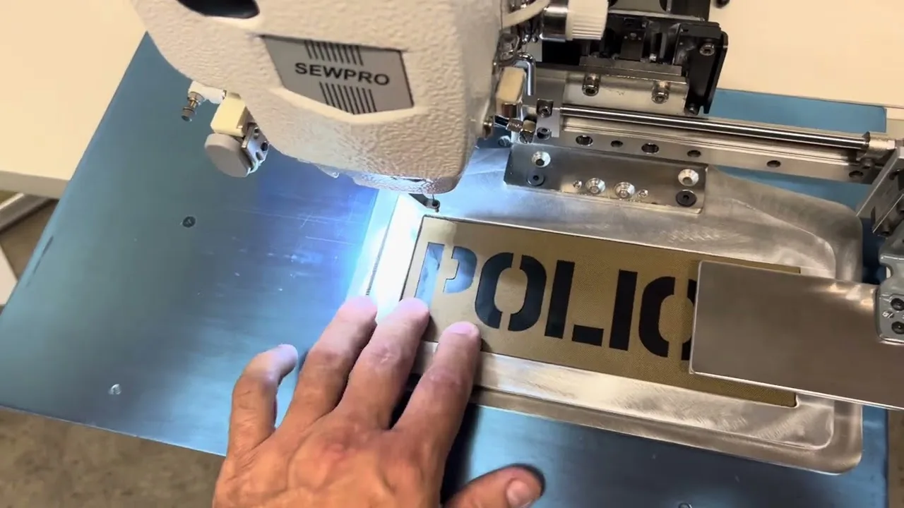 A stencilled label being sewn on a pattern machine