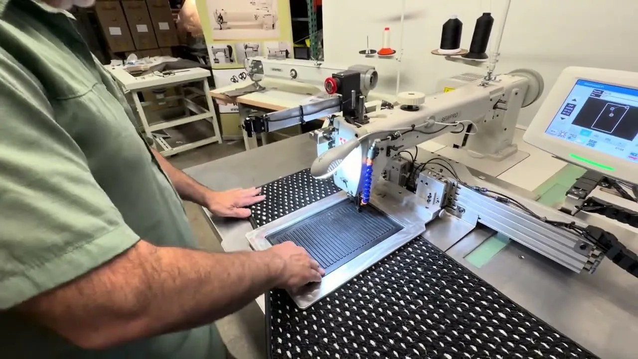 Sergey running a quilted panel through a SEWPRO programmable pattern sewer